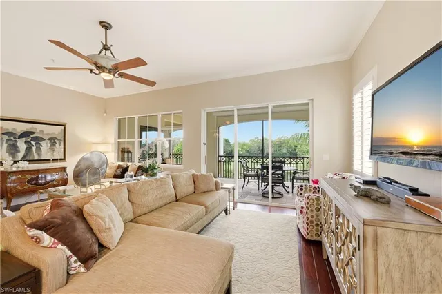 a living room with furniture a flat screen tv and a large window