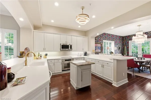 a kitchen with appliances a sink and cabinets