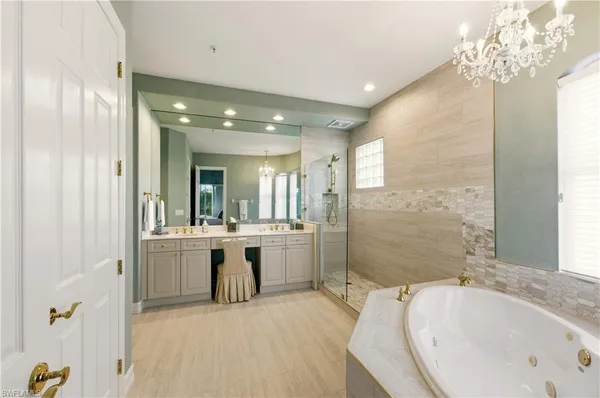 a bathroom with a tub sink shower and mirror