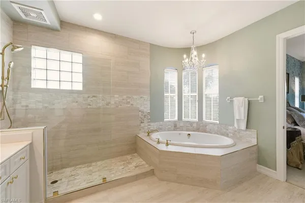 a bathroom with a bathtub and chandelier