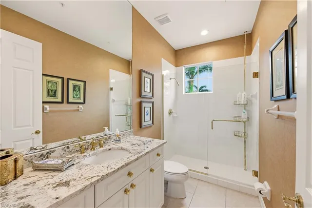 a bathroom with a granite countertop sink toilet and shower