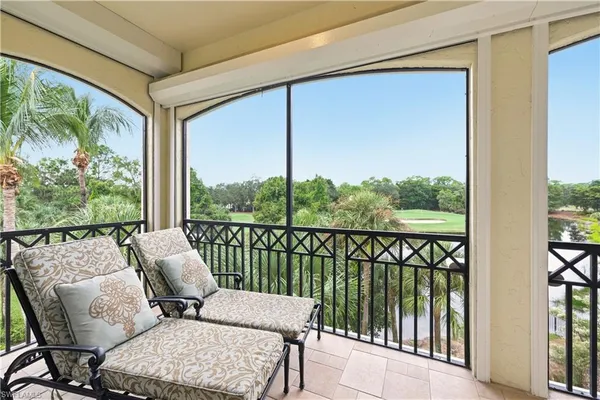 a balcony with furniture and a large window