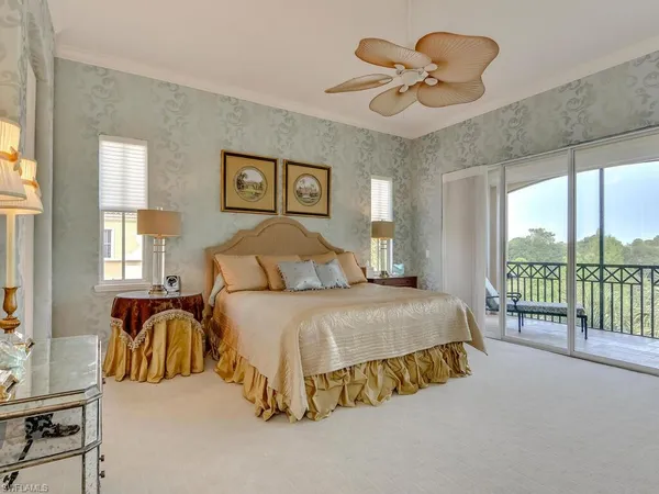 a spacious bedroom with a bed and a chandelier