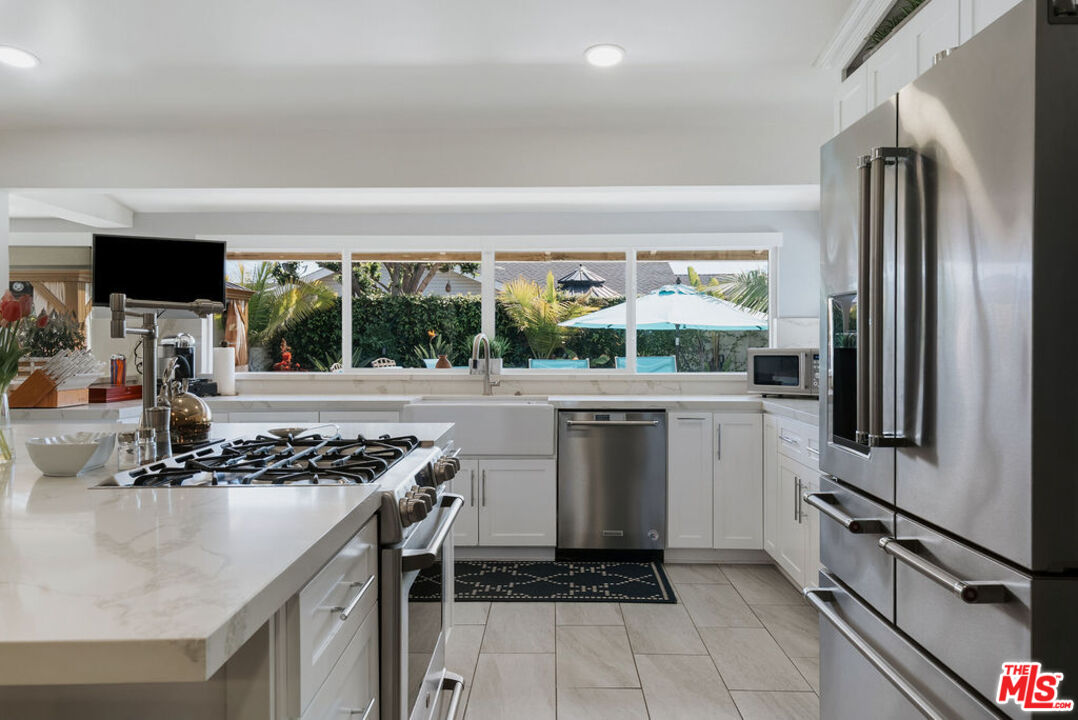 11332 Loch Lomond Road Los Alamitos, CA 90720 - Photo 22 of 55 a kitchen with stainless steel appliances a stove a sink and a refrigerator