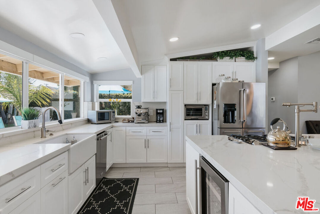 11332 Loch Lomond Road Los Alamitos, CA 90720 - Photo 23 of 55 a kitchen with a sink stove and refrigerator