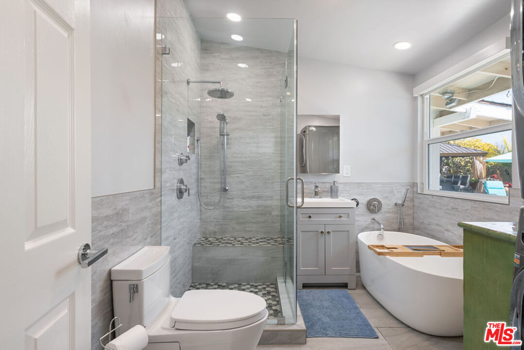 11332 Loch Lomond Road Los Alamitos, CA 90720 - Photo 40 of 55 a bathroom with a toilet a sink a tub and mirror