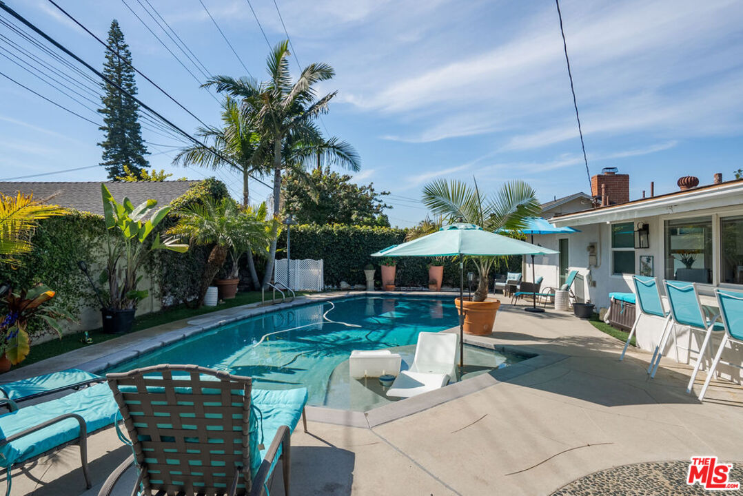 11332 Loch Lomond Road Los Alamitos, CA 90720 - Photo 47 of 55 a patio with a table and chairs under an umbrella