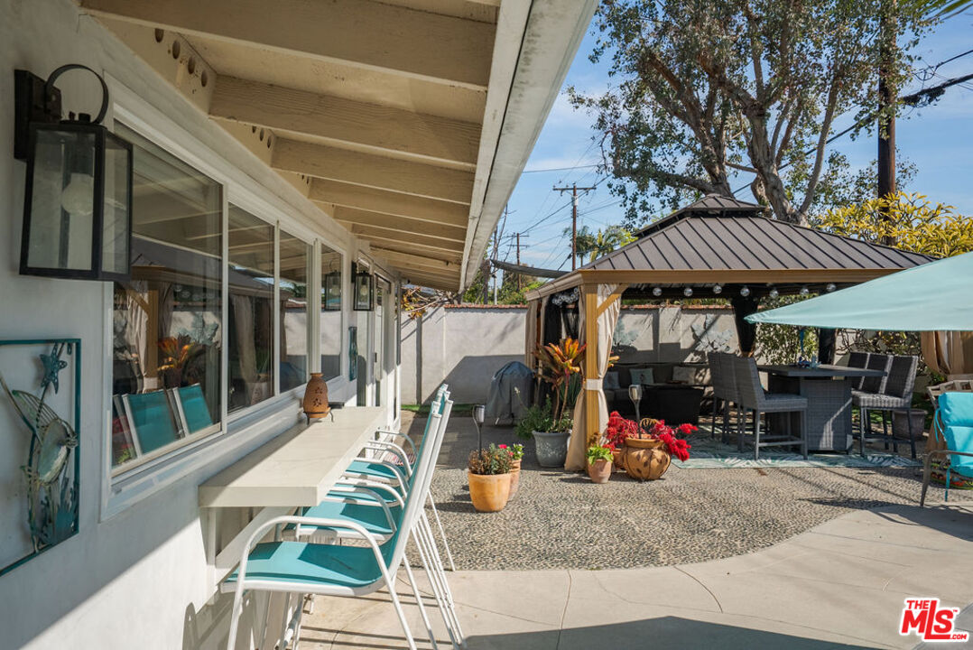 11332 Loch Lomond Road Los Alamitos, CA 90720 - Photo 52 of 55 a view of a patio with table and chairs under an umbrella