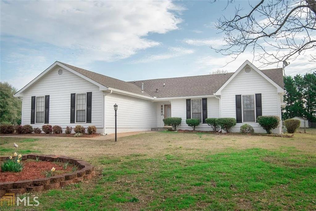 a view of a yard in front of a house with large tree