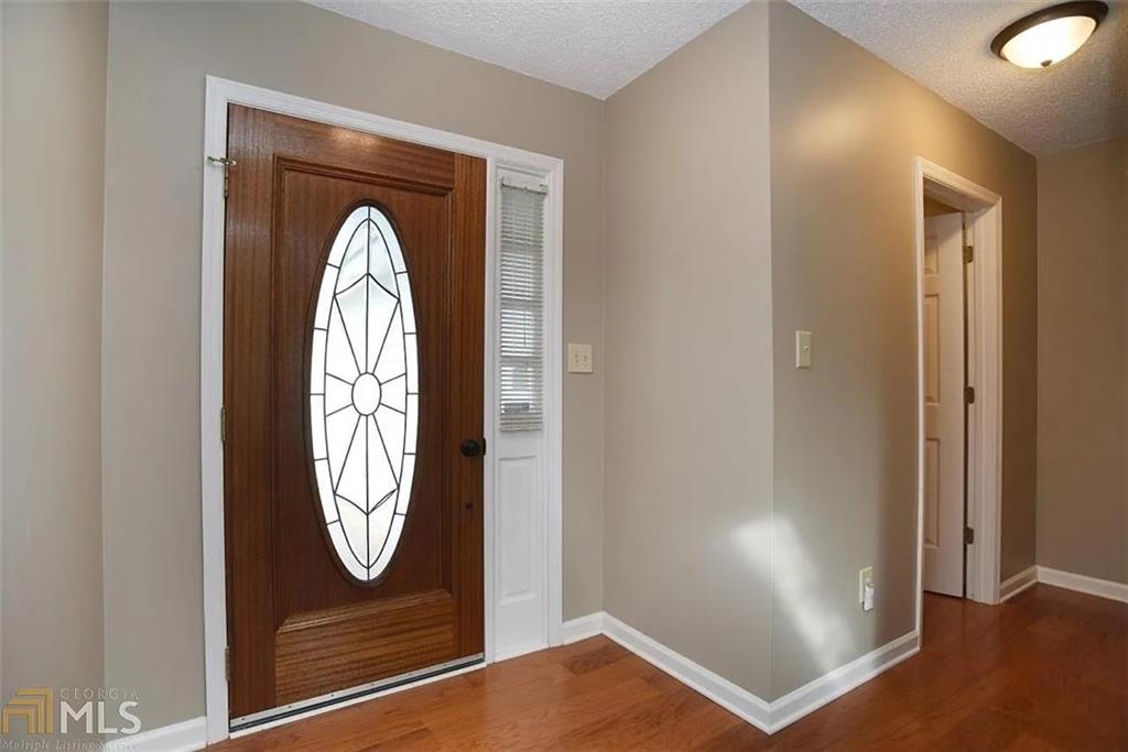 11058 Hunters Lane Hampton, GA 30228 - Photo 11 of 25 an entryway view with wooden floor and mirror