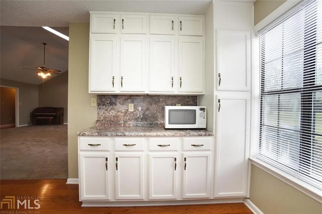 11058 Hunters Lane Hampton, GA 30228 - Photo 19 of 25 a kitchen with stainless steel appliances white cabinets and a stove top oven