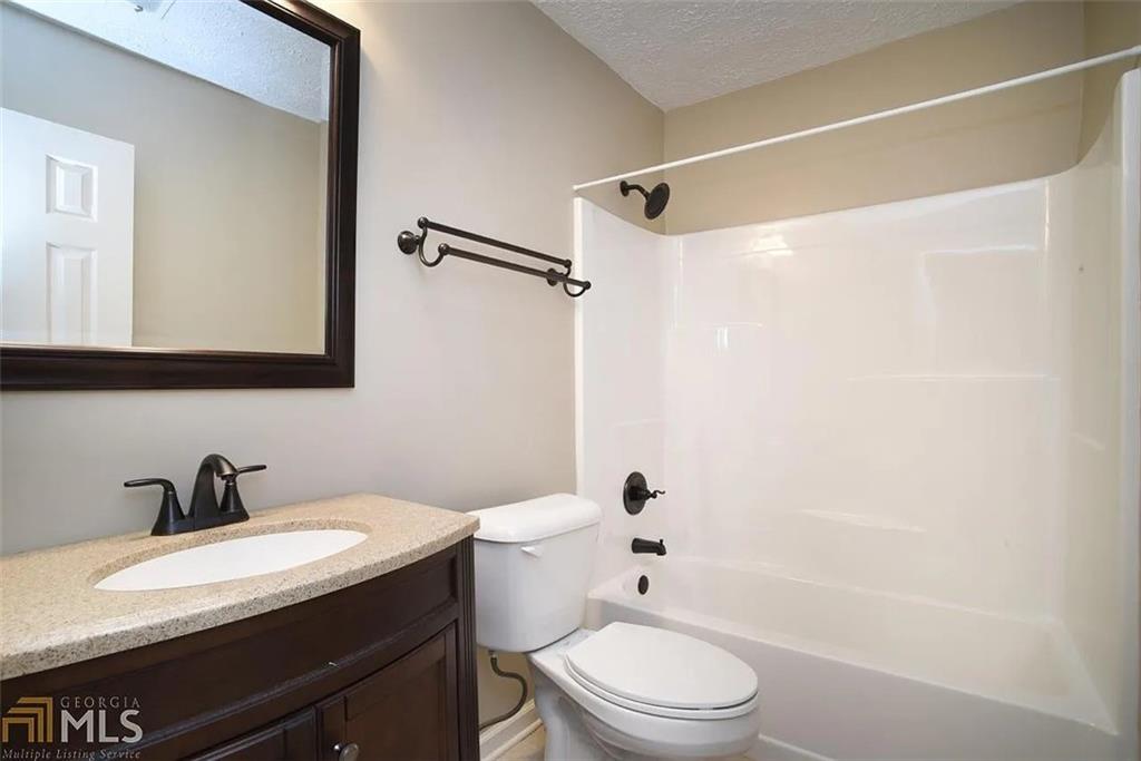 11058 Hunters Lane Hampton, GA 30228 - Photo 6 of 25 a bathroom with a sink a toilet and shower
