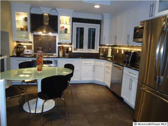 26 High Point Road Middletown, NJ 07738 - Photo 3 of 3 a kitchen with stainless steel appliances granite countertop a sink a stove a dining table and chairs