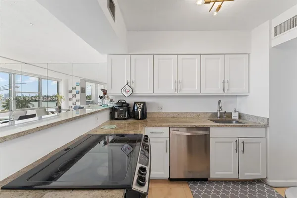 a kitchen with a sink a stove and cabinets