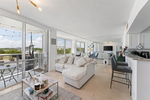 a living room with furniture and a view of kitchen
