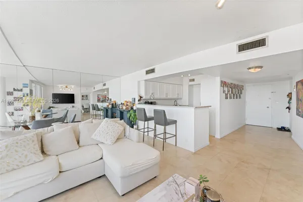a living room with furniture and a dining table with kitchen view