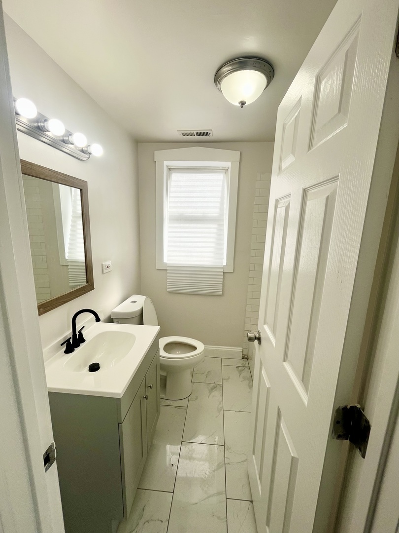 3636 West Iowa Street, Unit BF Chicago, IL 60651 - Photo 14 of 14 a bathroom with a sink a toilet and a mirror
