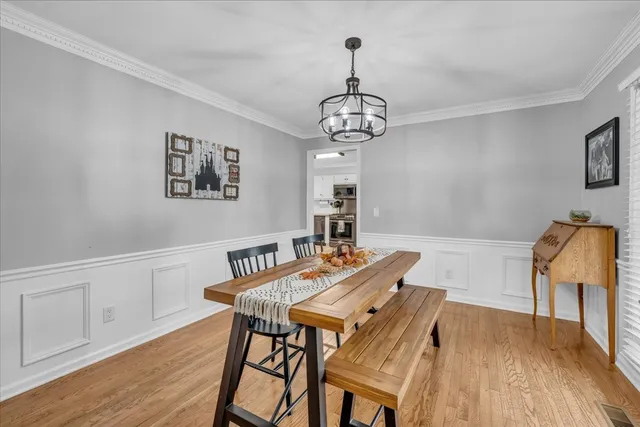 a view of a dining room with furniture wooden floor and chandelier