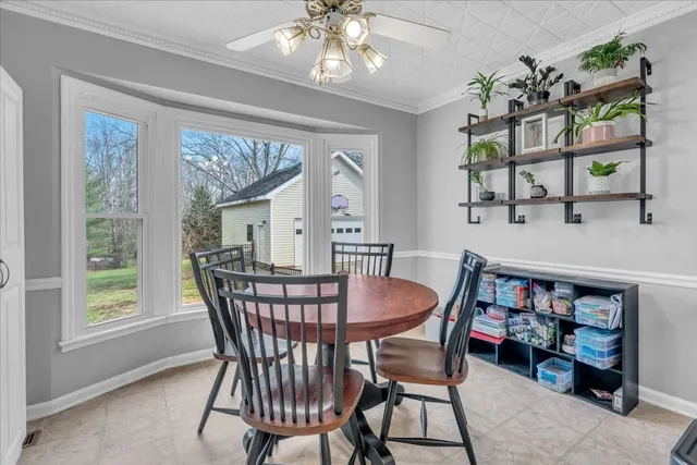 a view of a dining room with furniture a chandelier and a window