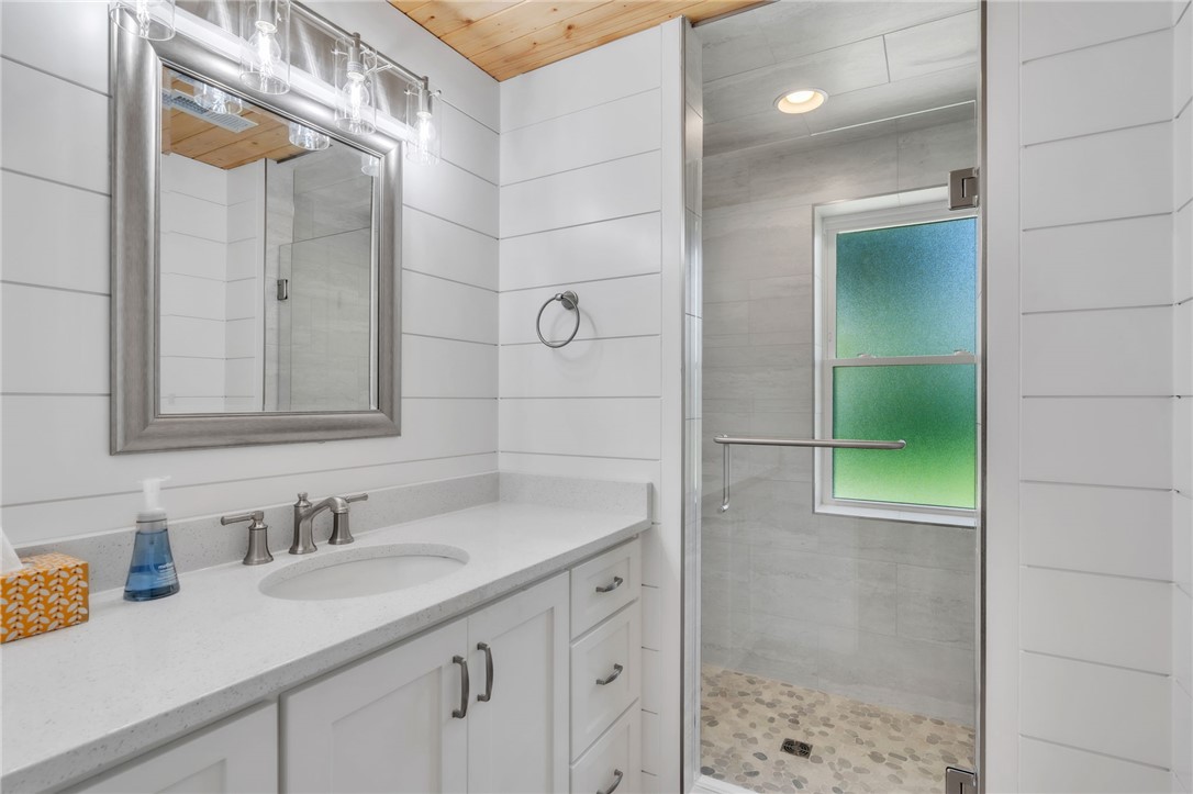 400 Arcadia Drive Anderson, SC 29621 - Photo 20 of 43 This bathroom features elegant shiplap walls, a spacious vanity, and a glass-enclosed shower.