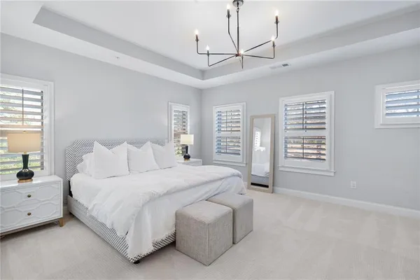 a spacious bedroom with a bed a dresser and a window