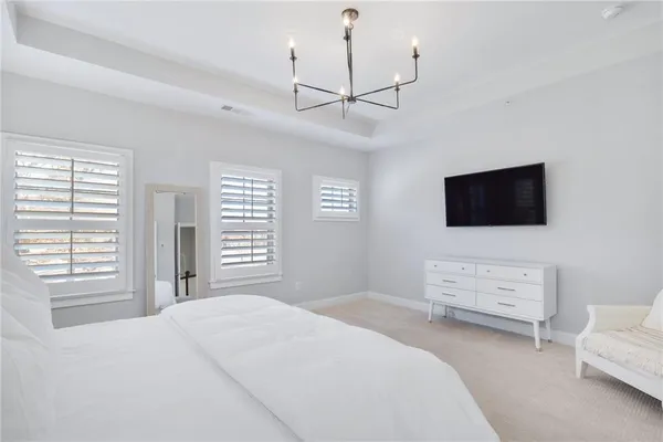 a bedroom with a bed a dresser and flat screen tv