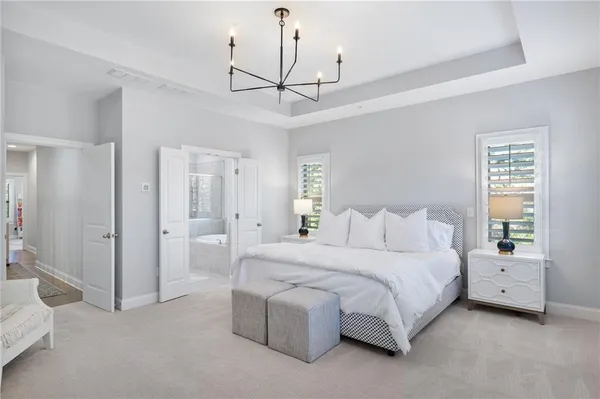 a bedroom with a bed chandelier and a window