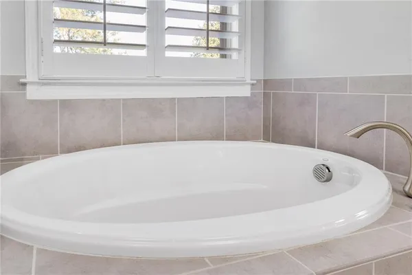 a white bath tub sitting in a bathroom next to a window