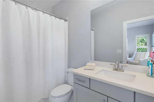 a bathroom with a sink a toilet and shower curtain