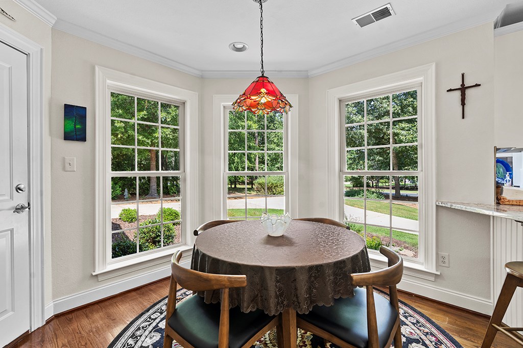 337 Compass Point Ninety Six, SC 29666 - Photo 10 of 43 a dining room with wooden floor a chandelier a wooden table and chairs