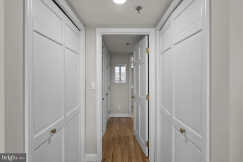 a view of a hallway with wooden floor and staircase