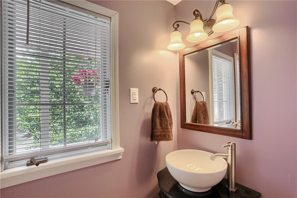 8381 Post Road Allison Park, PA 15101 - Photo 12 of 25 Completing the main level is a stylish powder room tucked at the front of the home, boasting a modern vanity with a vessel sink.