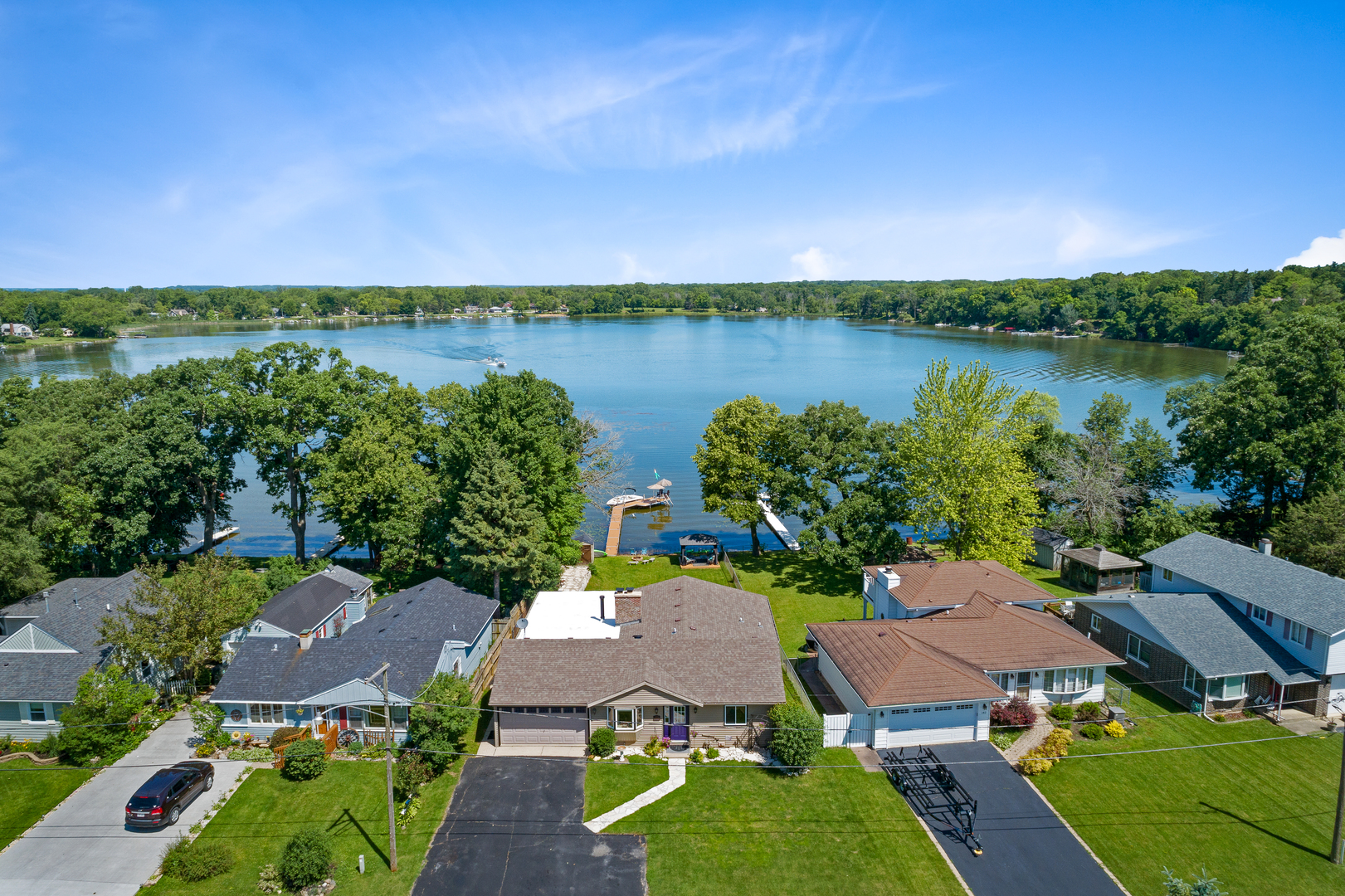 an aerial view of a house with outdoor space and lake view in back