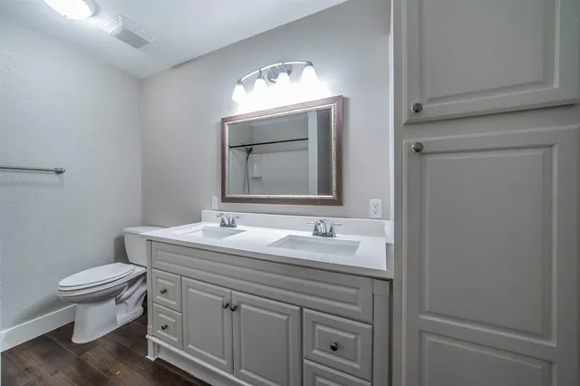 a bathroom with a toilet sink and mirror