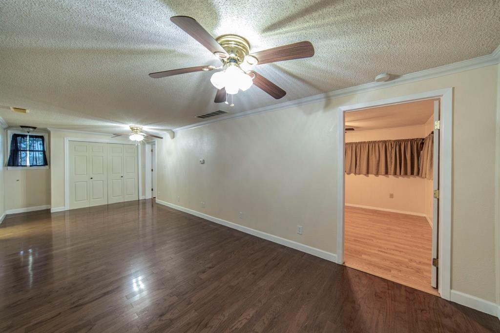 127 County Road 3051 Decatur, TX 76234 - Photo 14 of 35 an empty room with wooden floor fan and windows