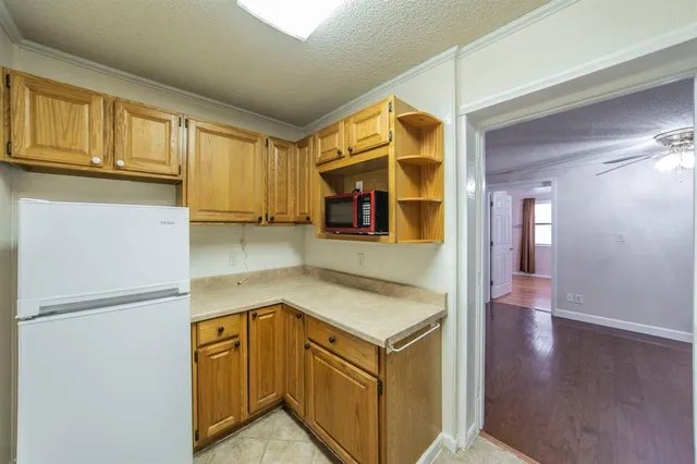 a kitchen with stainless steel appliances granite countertop a refrigerator a stove and a sink with wooden floor