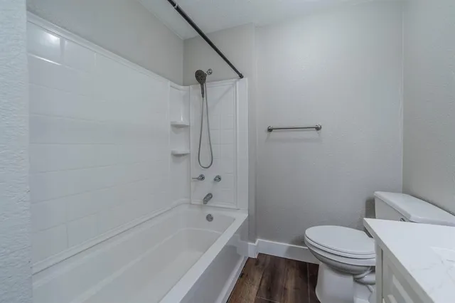 a white toilet sitting next to a bath tub and a shower
