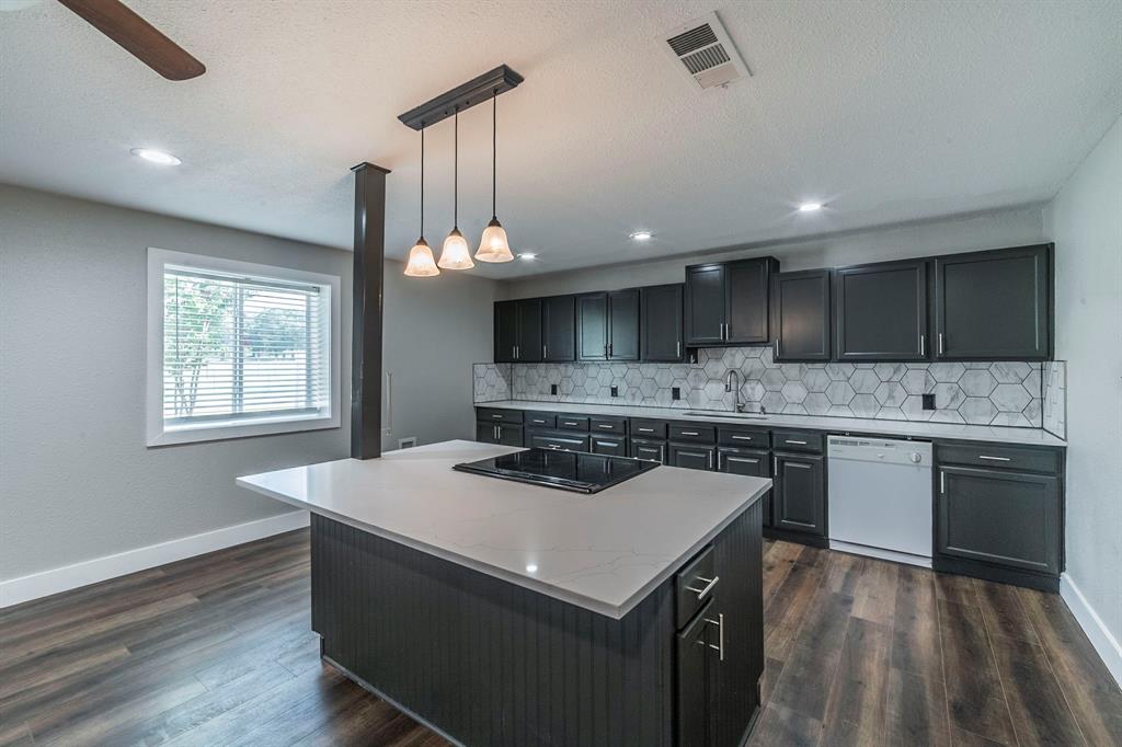127 County Road 3051 Decatur, TX 76234 - Photo 10 of 35 a kitchen with a sink a stove a microwave and island