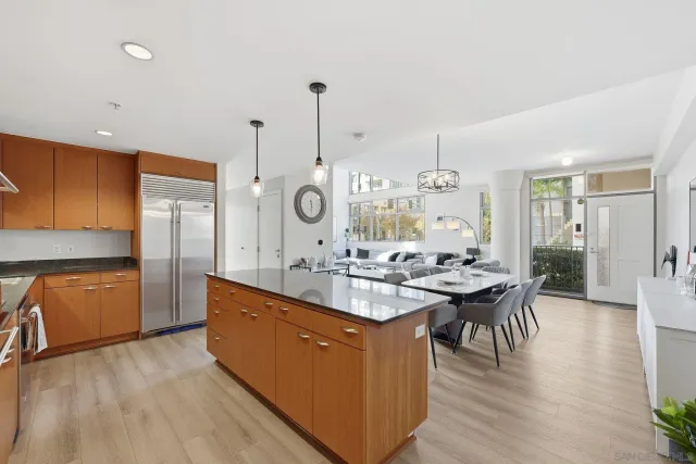 a kitchen with stainless steel appliances kitchen island granite countertop a stove a sink and a refrigerator