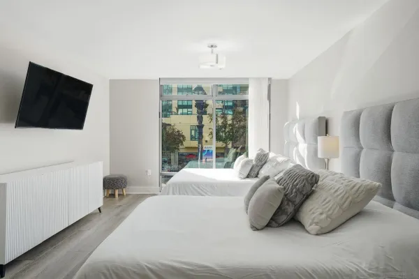 a spacious bedroom with a bed and a flat screen tv