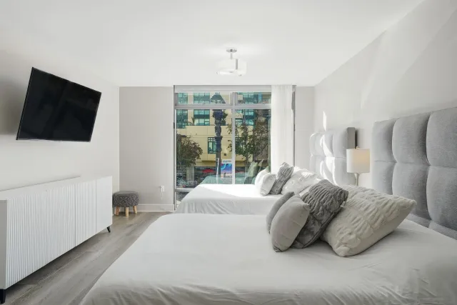 a spacious bedroom with a bed and a flat screen tv