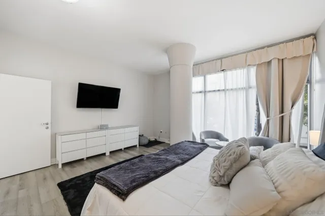a bedroom with a bed and a flat screen tv