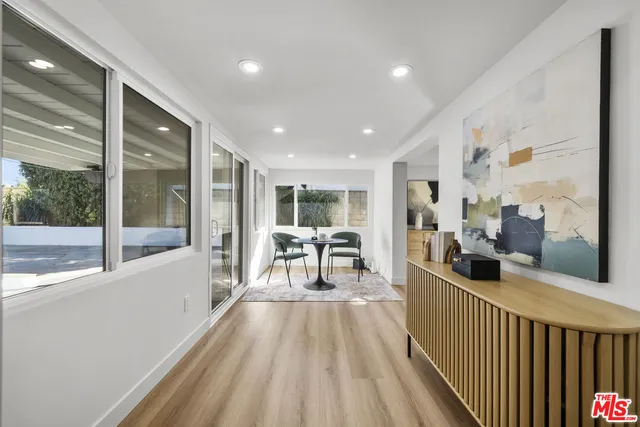a living room with furniture potted plant and kitchen view