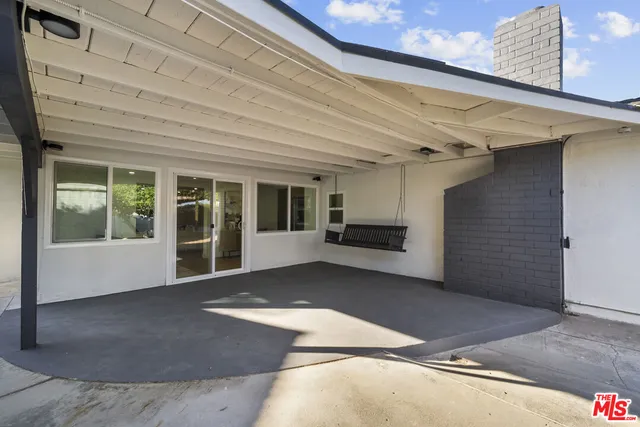 a view of a house with swimming pool and a porch with furniture