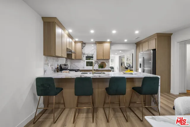 a kitchen with stainless steel appliances granite countertop a sink stove and cabinets