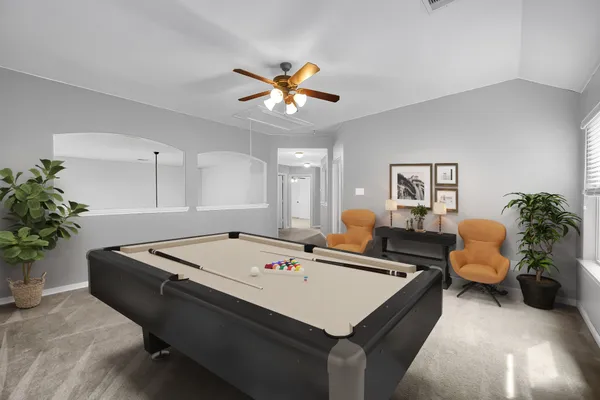 a room with a table chairs and a chandelier fan