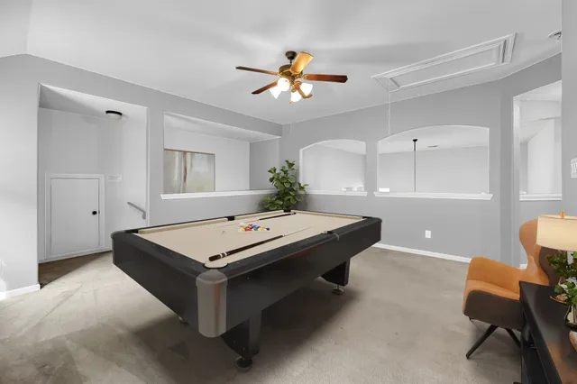 a living room with furniture a chandelier and a potted plant