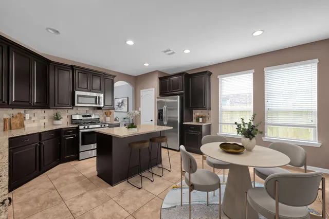 a large kitchen with kitchen island granite countertop a sink and cabinets