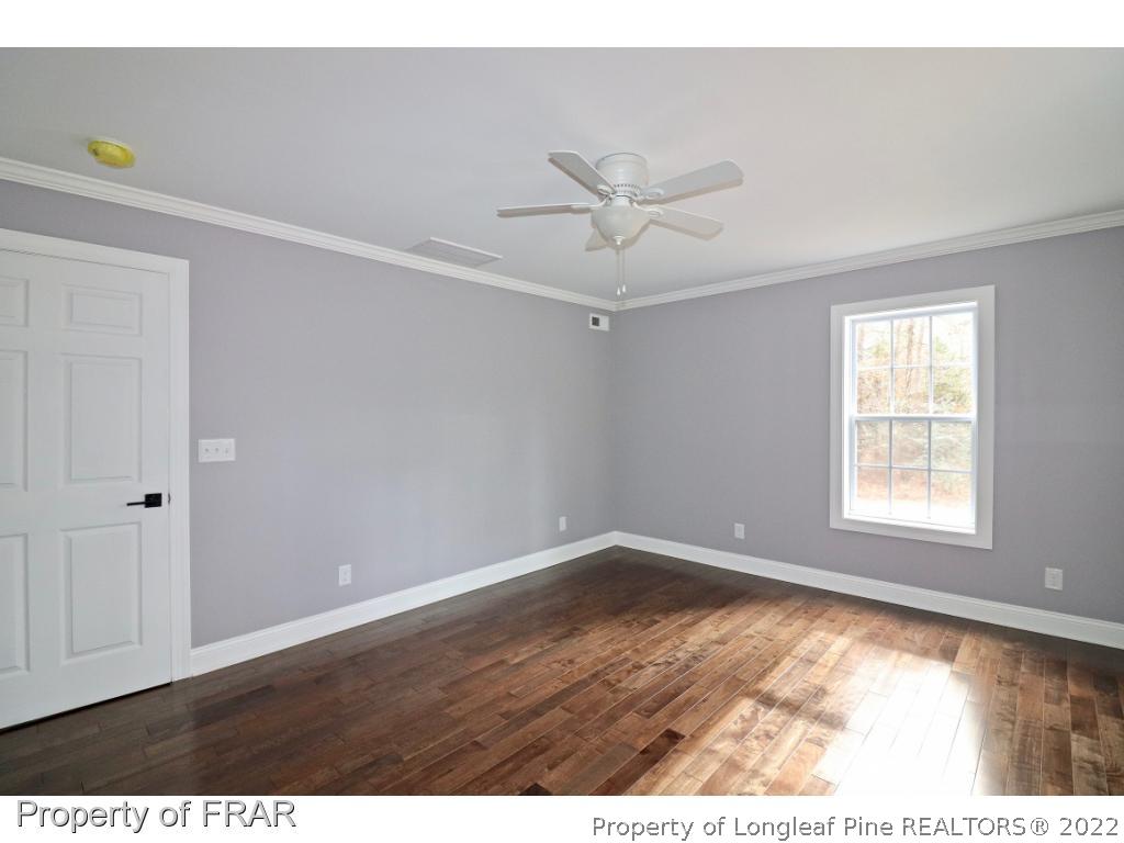 873 Morrison Bridge Road Vass, NC 28394 - Photo 24 of 35 a view of an empty room with wooden floor and a window
