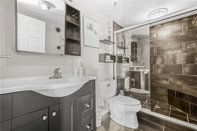 a bathroom with a sink toilet vanity and shower